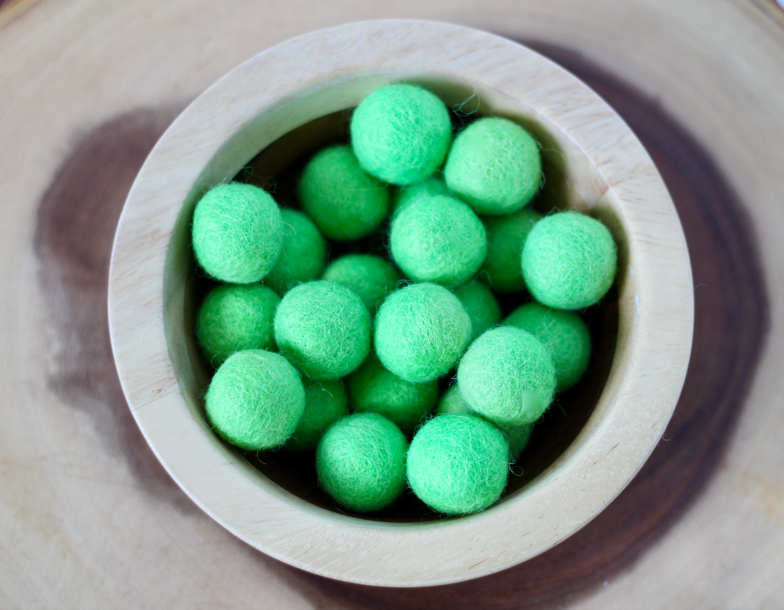 Green chunky felt balls for sensory play.